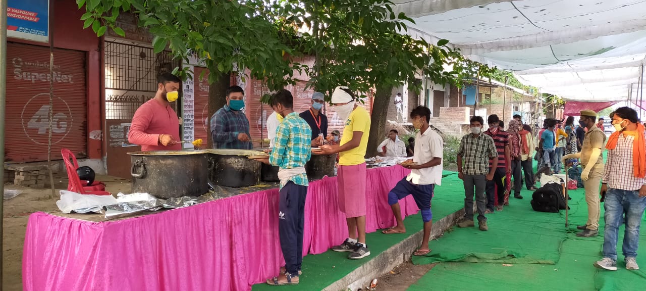अपने गृह जनपद जा रहे प्रवासी श्रमिकों को भोजन वितरण करते श्री काशी विश्वनाथ मंदिर न्यास के कोरोना वारियर्स